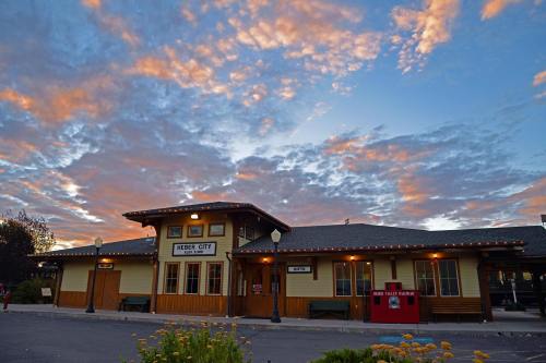 Historic train station with wooden architecture, set against a colorful sunset sky.