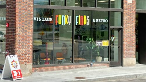 Storefront of "Vintage Funky Finds & Retro" with colorful signage and an open sign, showcasing a vibrant window display.