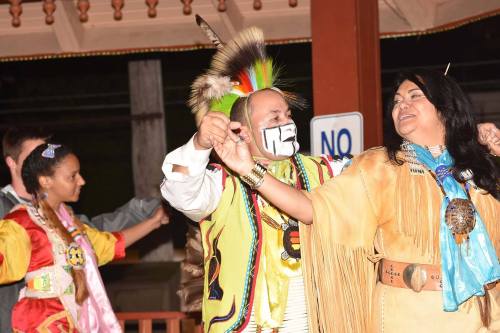 A group of people in traditional attire dance together, showcasing cultural heritage and celebration.