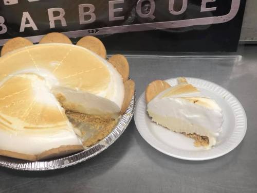 A whole pie with a slice removed, next to a plate with a single slice of creamy dessert.