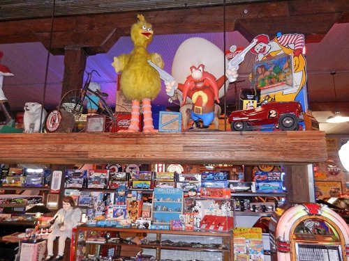 Colorful vintage toys and memorabilia displayed on shelves, featuring large characters and classic collectibles.