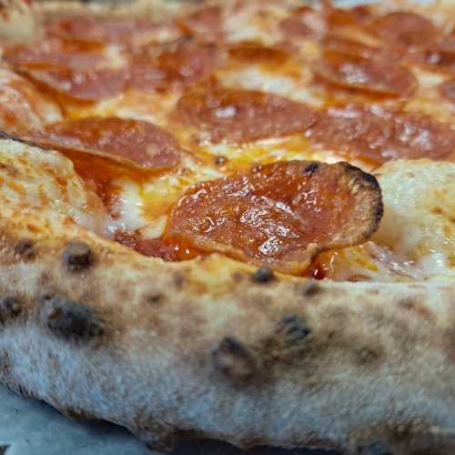 Close-up of a pepperoni pizza with melted cheese and a golden, crispy crust.