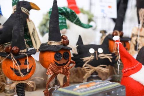 Decorative Halloween items featuring painted pumpkins with witch hats, a black cat, and a Santa figure.