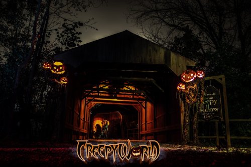 A spooky entrance to Creepy World, adorned with glowing jack-o'-lanterns and eerie lighting in a dark forest.