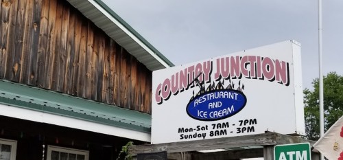 Sign for Country Junction restaurant and ice cream shop, with hours listed for Monday to Sunday.