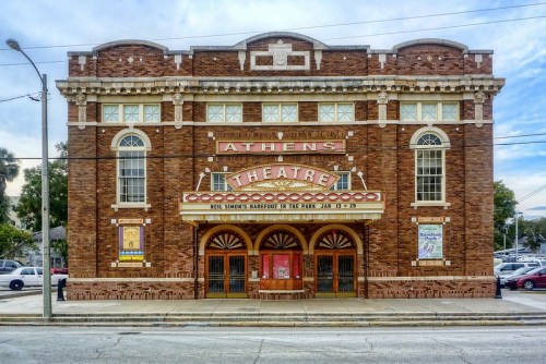 Historic Athens Theatre, a brick building with a marquee, featuring a classic architectural design and vibrant signage.