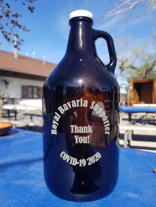 A dark glass growler with engraved text: "Royal Bavaria Supporter Thank You! COVID-19 2020."