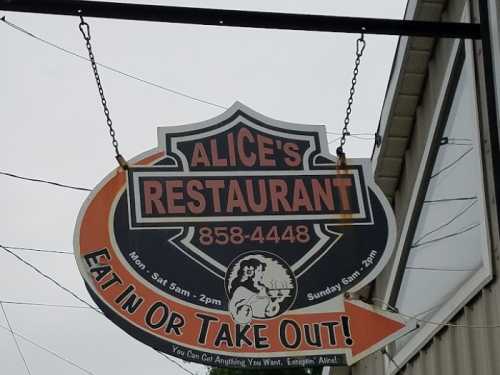 Sign for Alice's Restaurant, featuring contact number and hours: Mon-Sat 5am-2pm, Sun 5am-3pm. Eat in or take out!