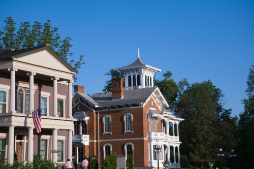 Historic buildings with ornate architecture under a clear blue sky, surrounded by lush greenery.