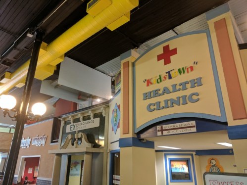 Interior view of a children's health clinic entrance, featuring colorful signage and a welcoming atmosphere.