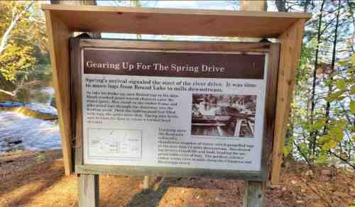 Sign titled "Gearing Up For The Spring Drive" with information about the area near Round Lake and its historical context.