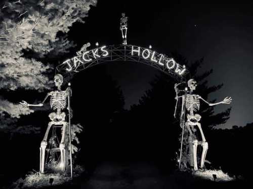 A spooky archway reading "Jack's Hollow," flanked by skeletons, set against a dark, eerie backdrop.