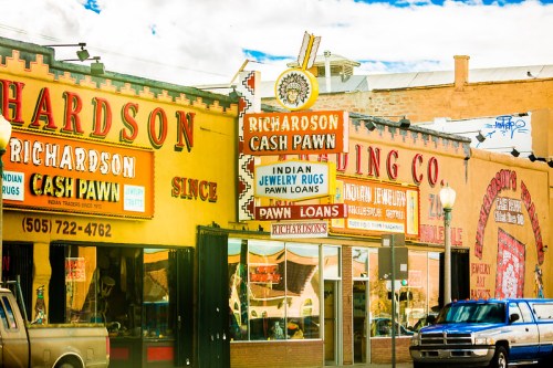 Colorful storefronts of Richardson Cash Pawn and other shops, featuring signs for pawn loans and Indian jewelry.