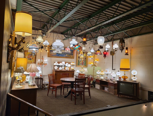 A cozy room filled with various hanging and table lamps, showcasing a warm, inviting atmosphere.