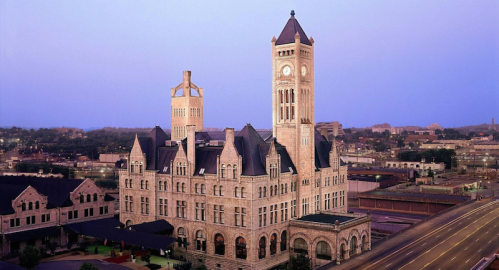 Historic building with a clock tower, featuring intricate architecture, set against a twilight sky.