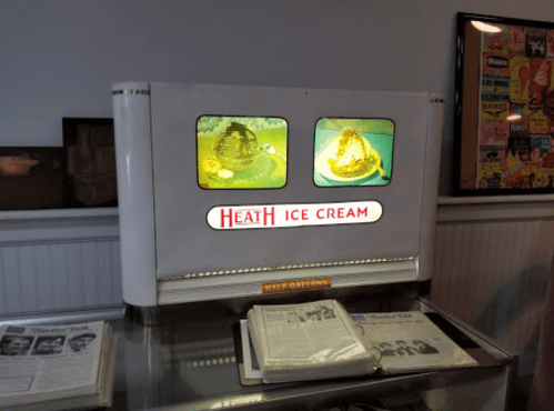 Vintage ice cream display featuring "Heath Ice Cream" with colorful images of ice cream sundaes.