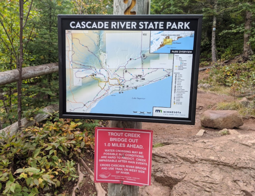 Map of Cascade River State Park with a warning sign about Trout Creek bridge conditions ahead.