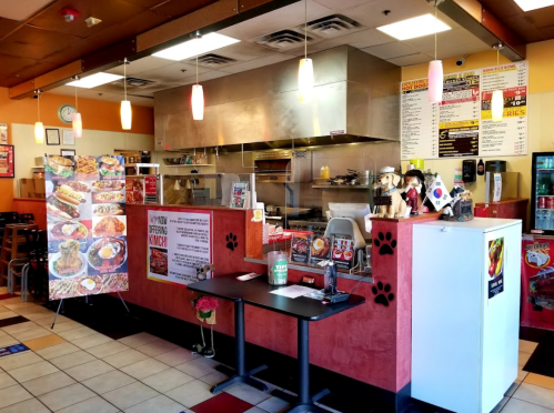 Interior of a casual restaurant featuring a service counter, menu boards, and tables with a cozy atmosphere.