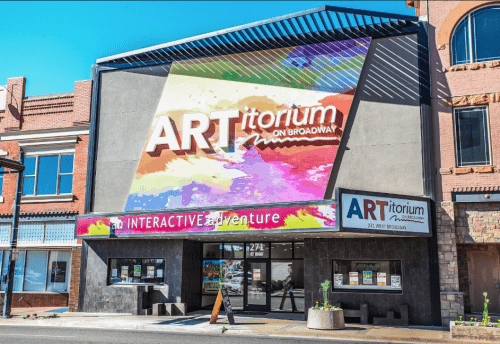 Colorful building facade of ARTitorium on Broadway, featuring a vibrant mural and interactive adventure signage.