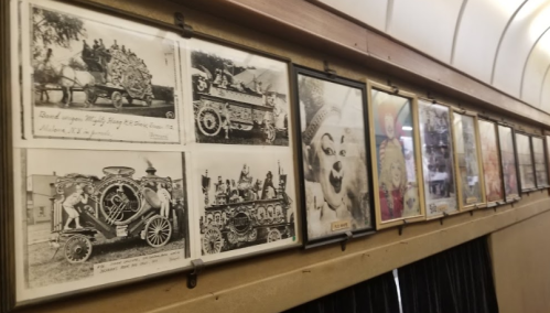 A series of vintage black-and-white photos displayed in frames, featuring decorated vehicles and circus scenes.