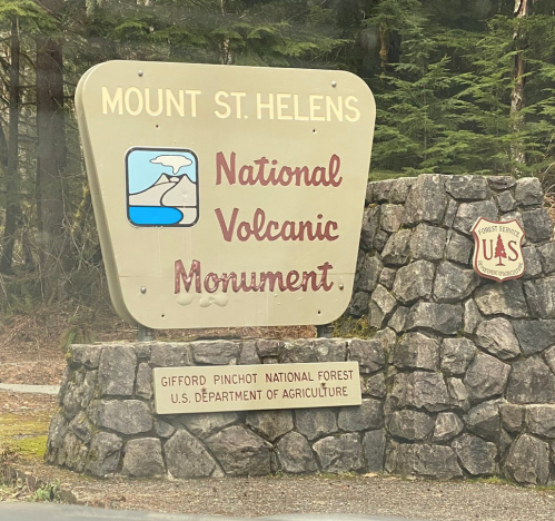 Sign for Mount St. Helens National Volcanic Monument, featuring a scenic logo and information about the Gifford Pinchot National Forest.