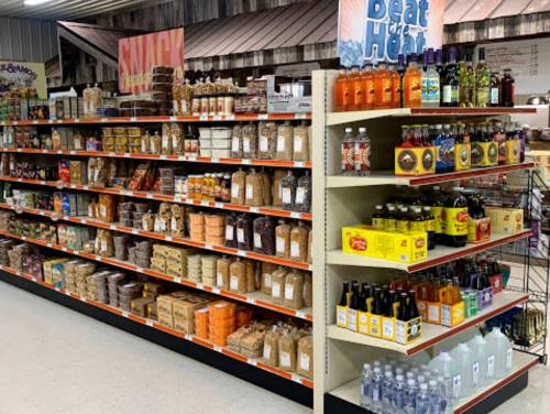 A grocery store aisle filled with various packaged foods, snacks, and beverages on shelves.