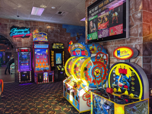 Colorful arcade games and machines in a vibrant entertainment center, featuring various gaming options and bright lights.