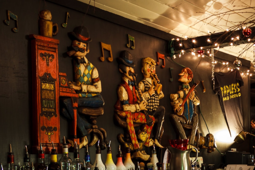 Wooden figurines of musicians playing instruments, decorated with musical notes and surrounded by bar elements.
