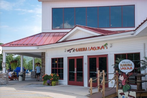 Exterior of Kahuna Laguna, a welcoming building with a red roof and colorful signage, surrounded by greenery.