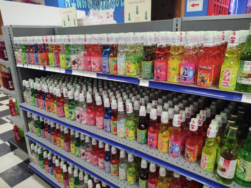 A colorful display of various flavored soda bottles on shelves in a store.
