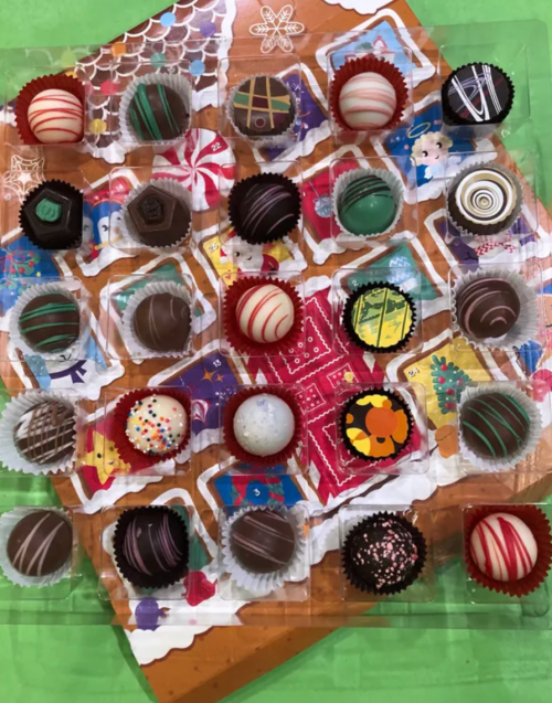 A colorful assortment of chocolate truffles arranged in a festive pattern on a decorative background.