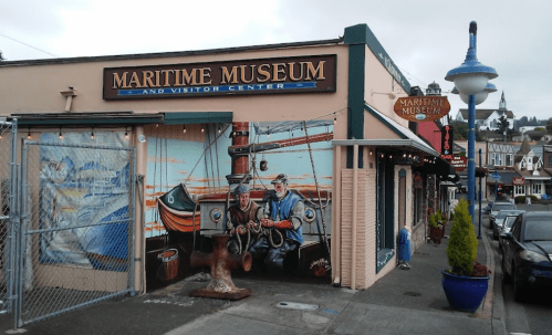 Exterior of the Maritime Museum and Visitor Center, featuring a colorful mural of fishermen and nautical scenes.