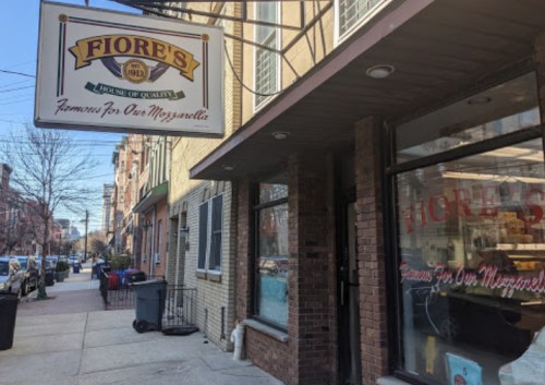 Exterior of Fiore's, a shop with a sign reading "Famous for Our Mozzarella," on a city street.