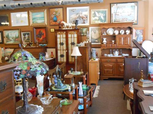 A cozy antique shop filled with wooden furniture, vintage decor, and various collectibles displayed on shelves and tables.