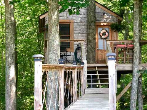 A cozy treehouse nestled among trees, featuring a wooden deck and a welcoming front door with a wreath.