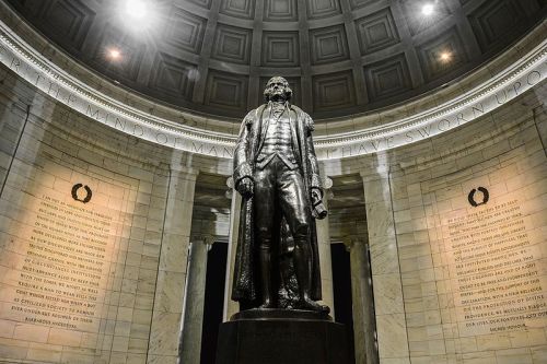 A large statue of Thomas Jefferson stands in a circular memorial, surrounded by stone walls with inscriptions.