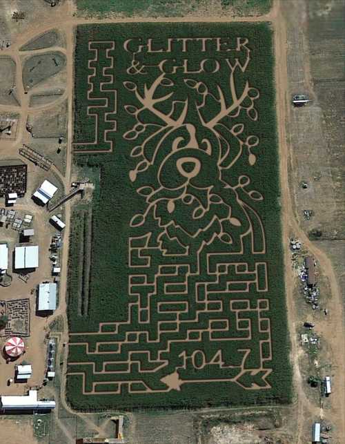 Aerial view of a corn maze featuring a reindeer design with the text "Glitter & Glow" and "104.7."