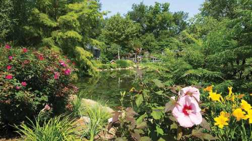 A serene garden scene featuring vibrant flowers and a tranquil pond surrounded by lush greenery.