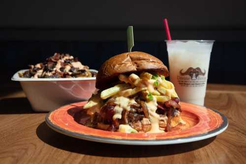 A hearty burger topped with bacon and cheese, served with a side of loaded fries and a milkshake.