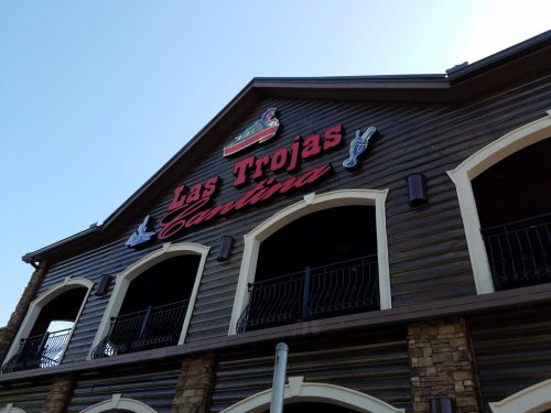 Signage of "Las Trojas Cantina" on a wooden building with a clear blue sky above.