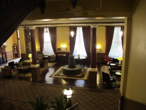 A spacious, elegantly decorated lobby with seating areas, large windows, and a central fountain.