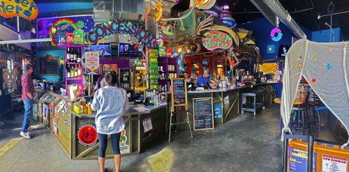 A vibrant concession area with colorful decor, featuring a counter, patrons, and a lively atmosphere.