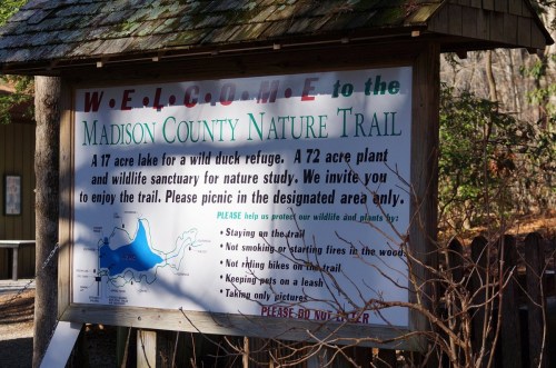 Sign welcoming visitors to Madison County Nature Trail, featuring rules and a map of the area.