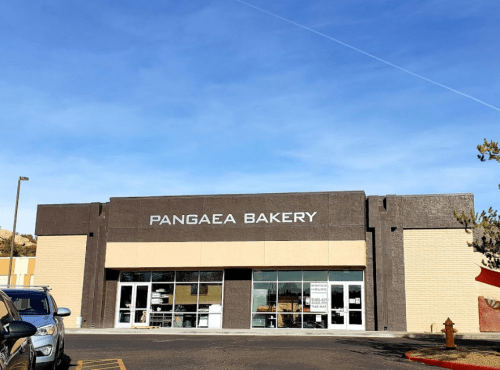 Exterior of Pangaea Bakery, featuring large windows and a clear blue sky above.