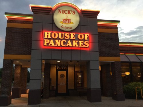 Exterior of Nick's House of Pancakes, featuring a bright sign and a welcoming entrance at dusk.
