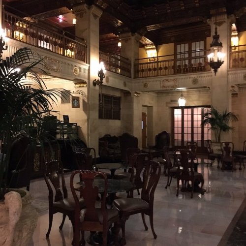 Elegant interior of a historic building featuring ornate architecture, wooden furniture, and soft lighting.