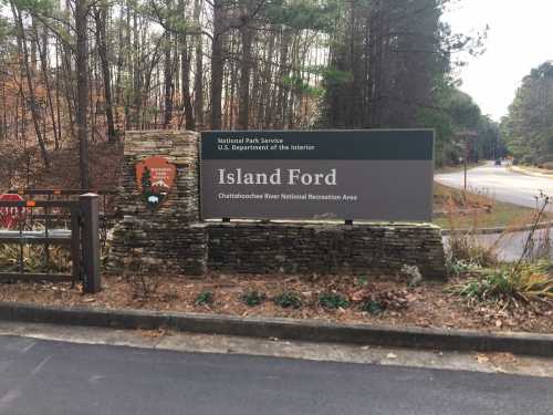 Sign for Island Ford, part of the Chattahoochee River National Recreation Area, surrounded by trees and foliage.