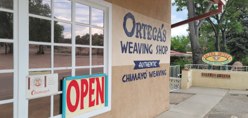 Exterior of Ortega's Weaving Shop with an "Open" sign, showcasing authentic Chimayo weaving.