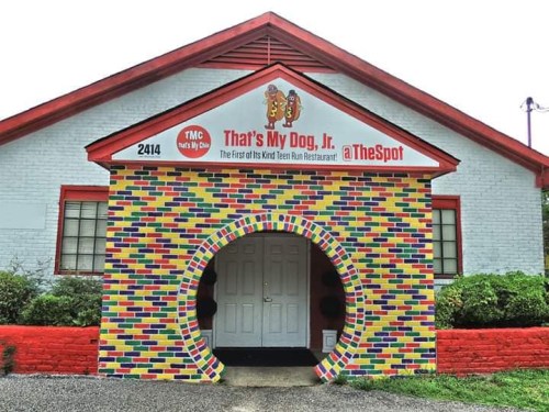 Colorful brick archway entrance to "That's My Dog, Jr." restaurant, featuring a playful sign and vibrant exterior.