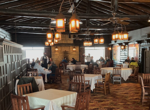 A cozy restaurant interior with wooden tables, warm lighting, and diners enjoying their meals.